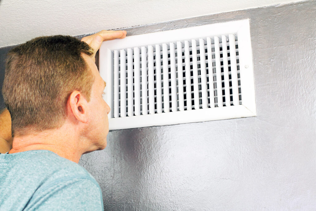 photo of a homeowner inspecting his air duct