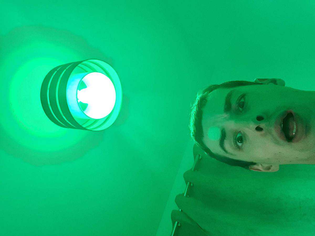 A LIFX bulb with green light and me taking a selfie