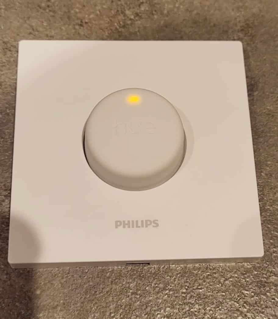 A Philips Hue Smart Button with a green or orange LED light flashing