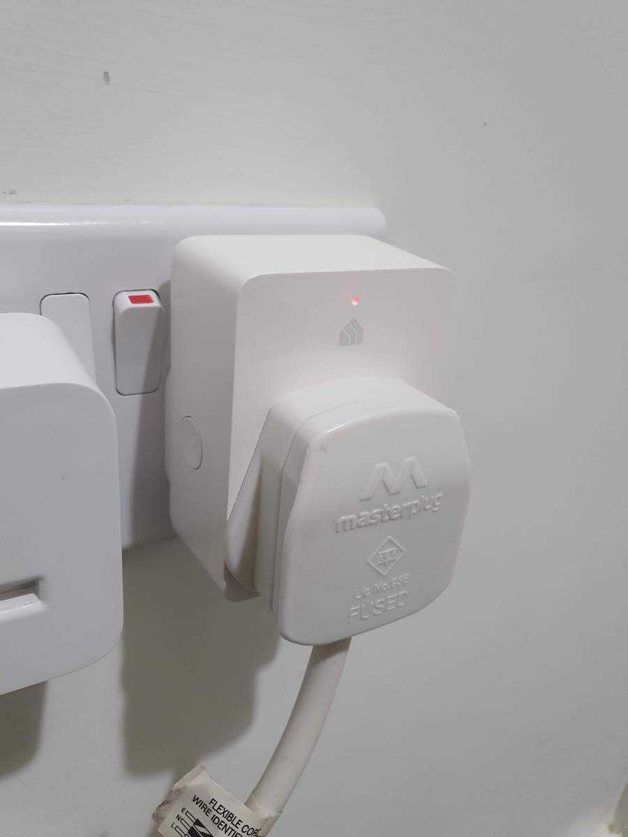 A TP Link Kasa smart plug with a strip plug plugged into it