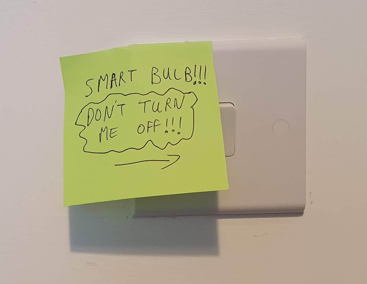 A sticky note put over a standard wall switch, saying "Smart bulb!!! Don't turn me off!!!"