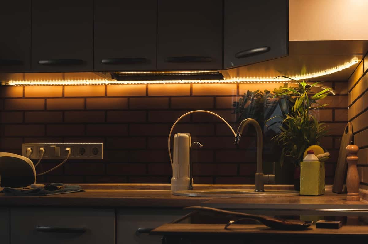 Dark kitchen with light strip below wall cabinets