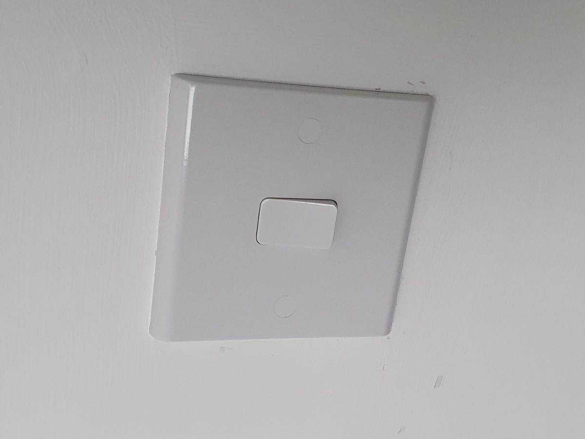 A dumb UK light switch (single gang) which is in the 'off' position - meaning no power is flowing to the light bulb.