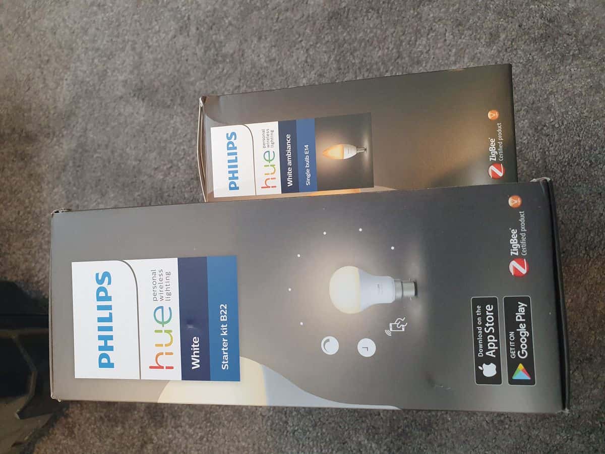 The boxes for the Philips Hue B22 Starter Kit and the Philips Hue White Ambiance E14 bulbs, both of which say "ZigBee Certified product" on their side.