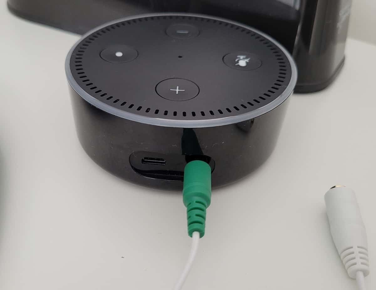 Inserting an aux cable into the back of an Amazon Echo device