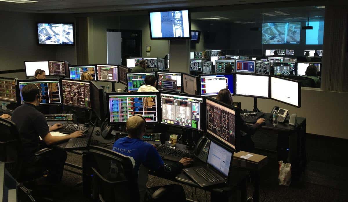 SpaceX staff working in their control centre during a launch, with lots of computer monitors at each desk each