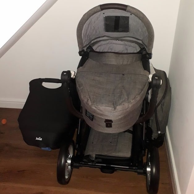 A pram and car baby seat, stored under our stairs in the hallway.