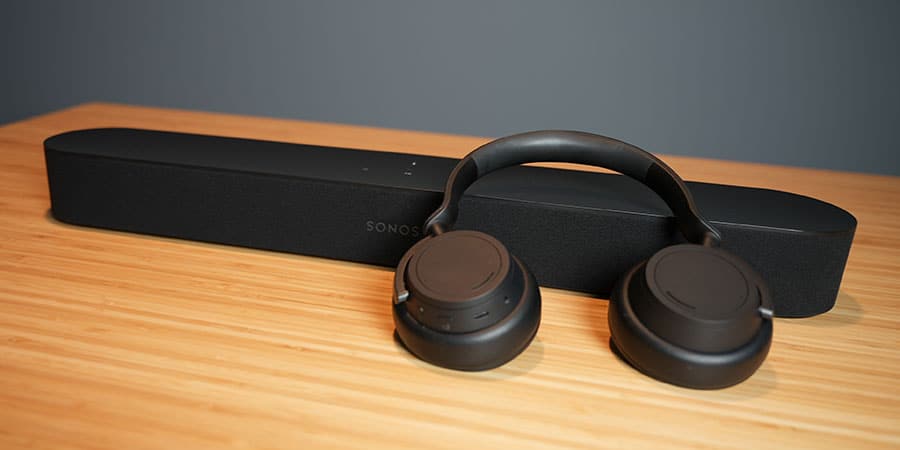 Sonos Beam Soundbar and Microsoft Surface Headphones on a wood table