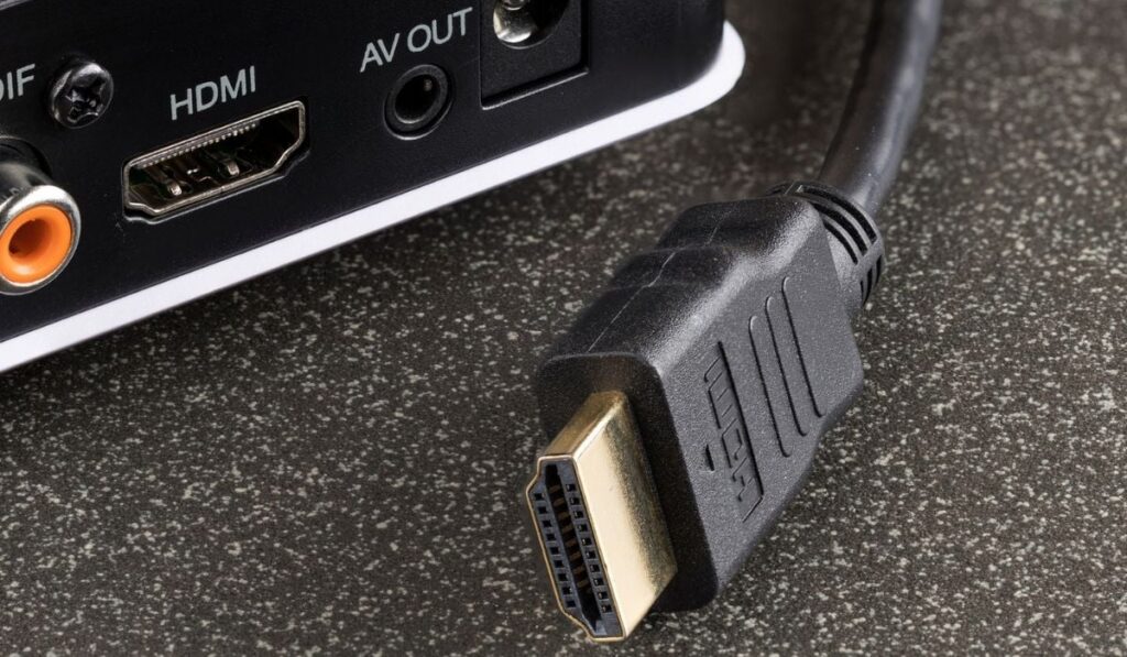 a close-up of an hdmi cable for a TV set-top box is pulled out of it