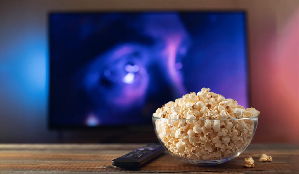 close up of a popcorn bowl and tv controller in a living room