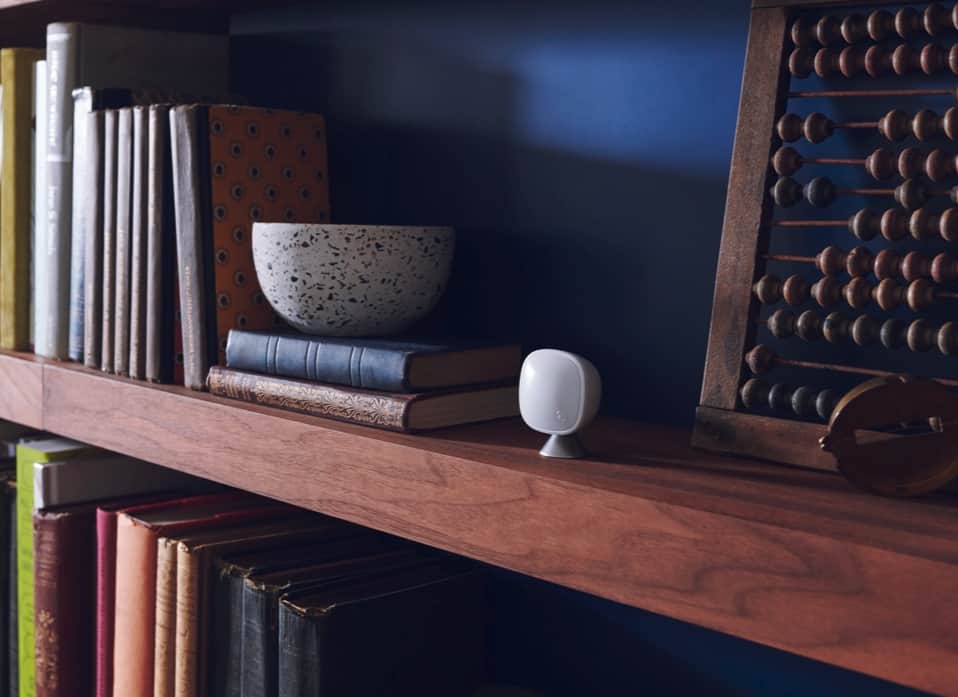 An ecobee room sensor on a bookcase shelf.