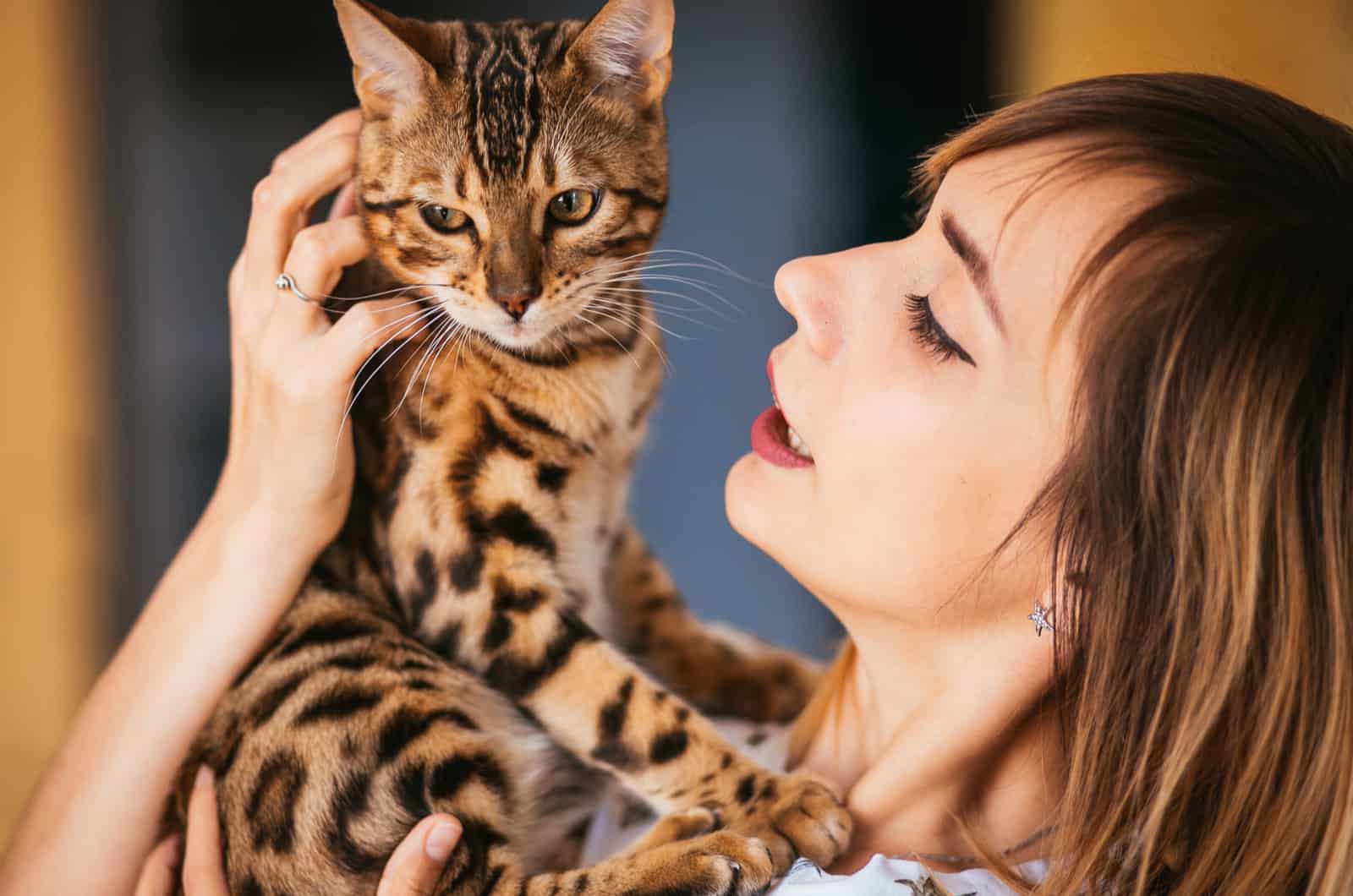 Blonde woman holds a Bengal cat