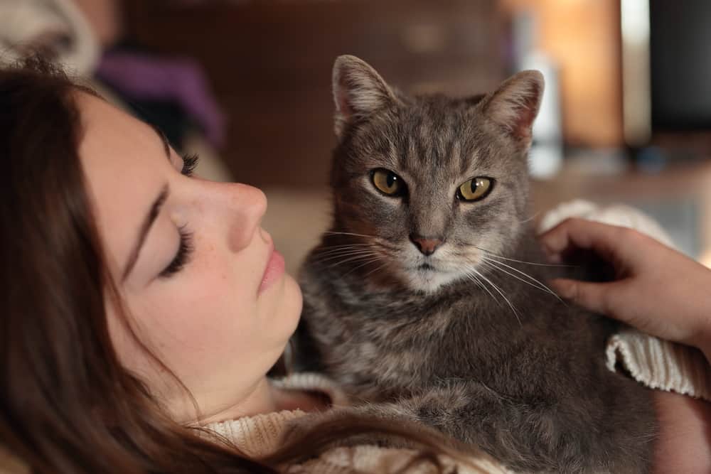 owner looking lovingly at cat wondering if her cat knows how much they are loved