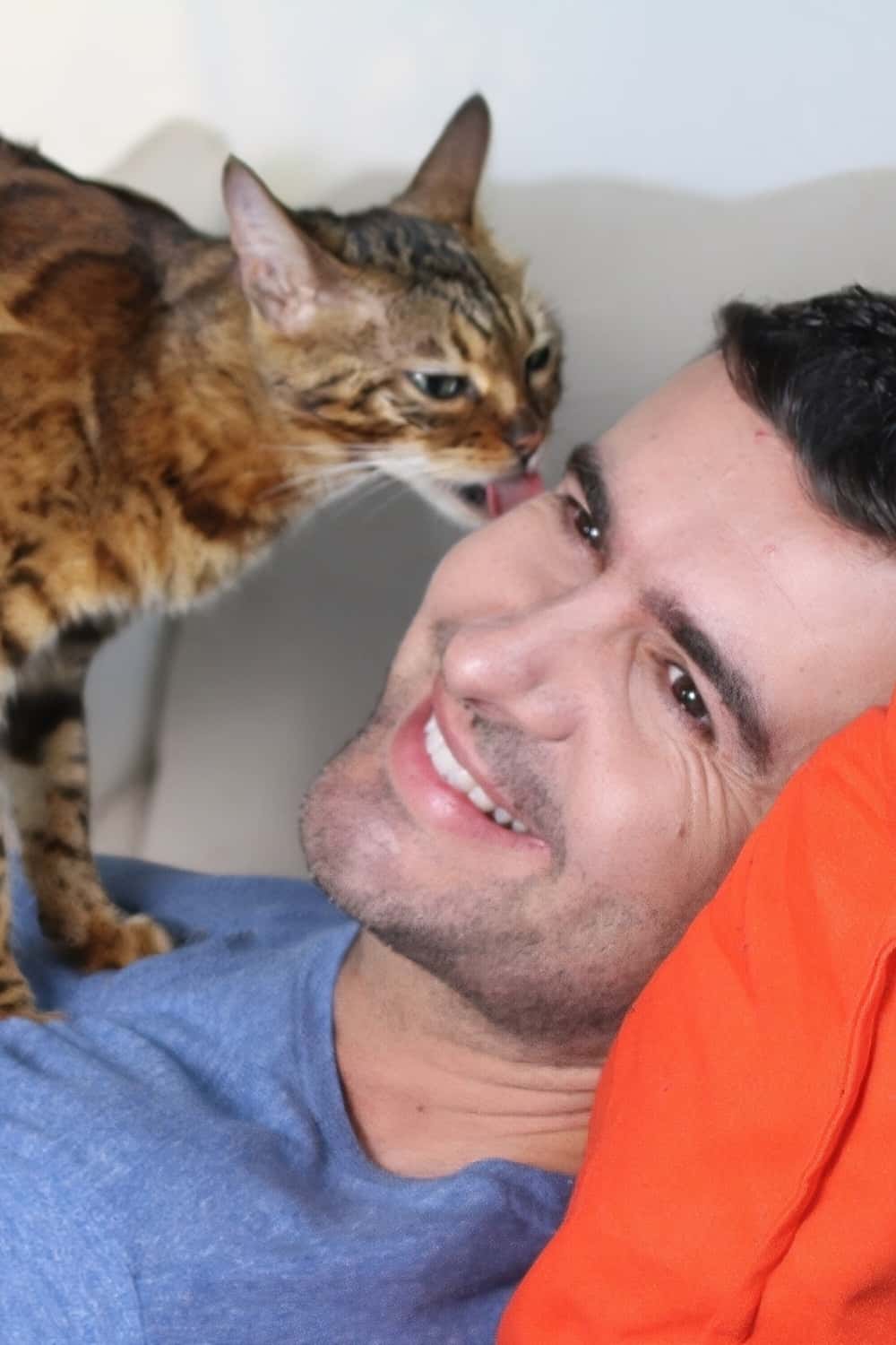 cat licking man's eye