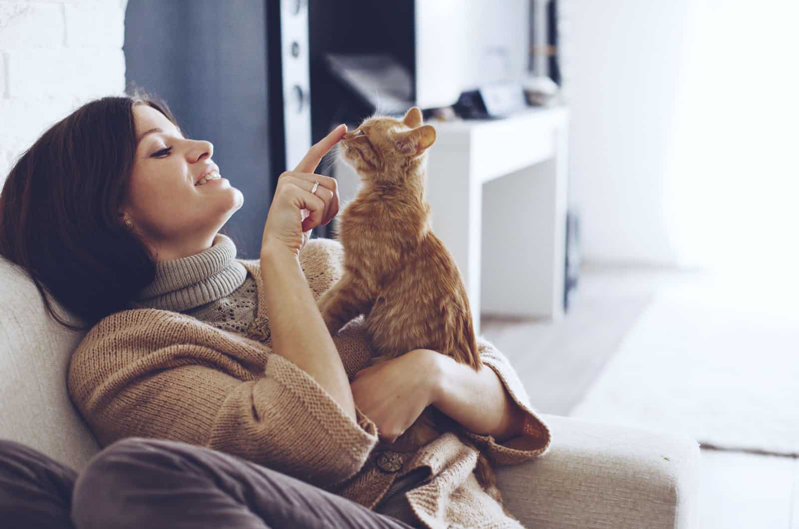 woman playing with cat