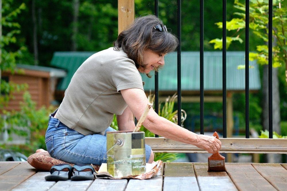 Woman painting on wood porch