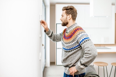 Man adjusting the thermostat temperature