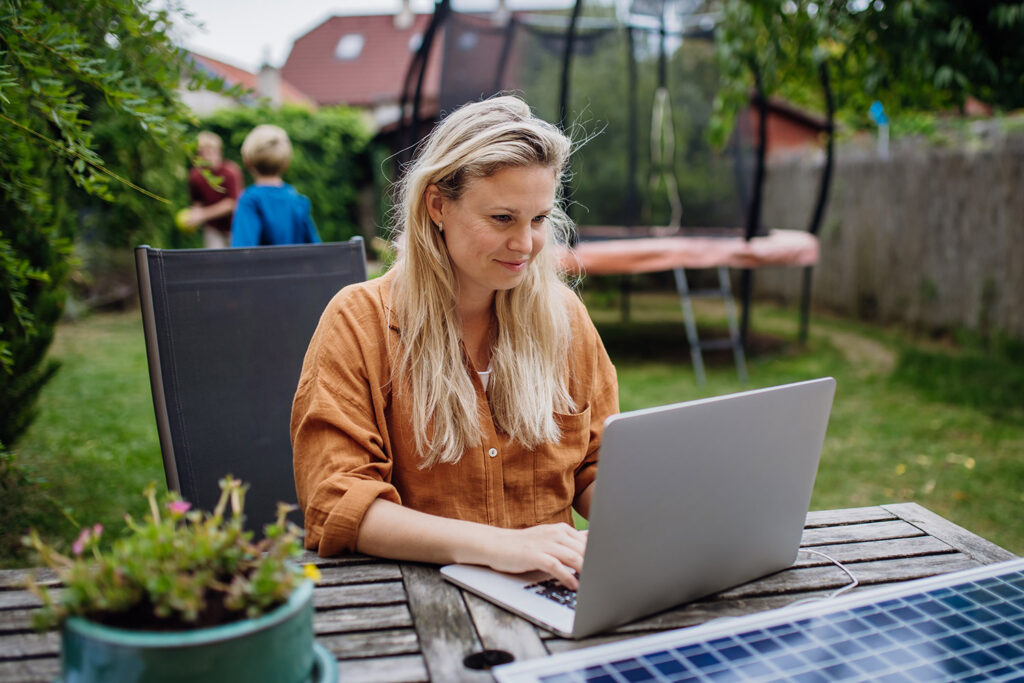 photo of a woman outside accessing Earthlink internet with a laptop