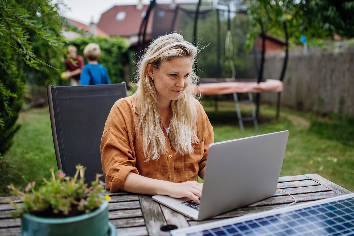 photo of a woman outside accessing Earthlink internet with a laptop