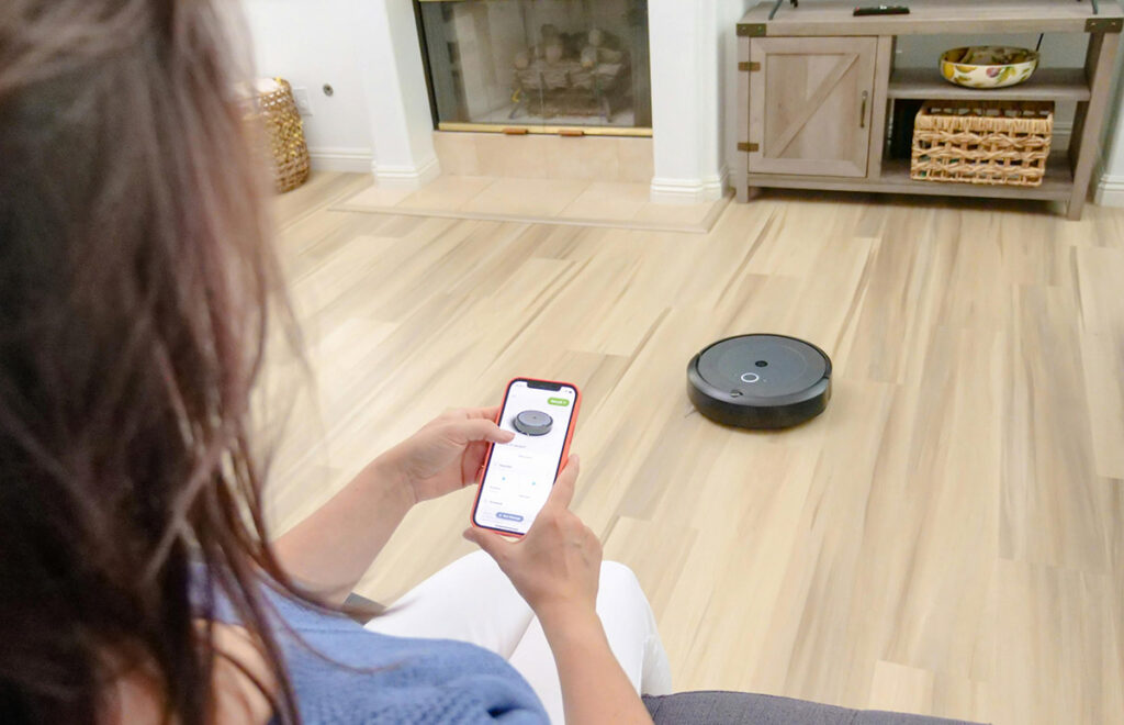 photo of a woman controlling her robot vacuum