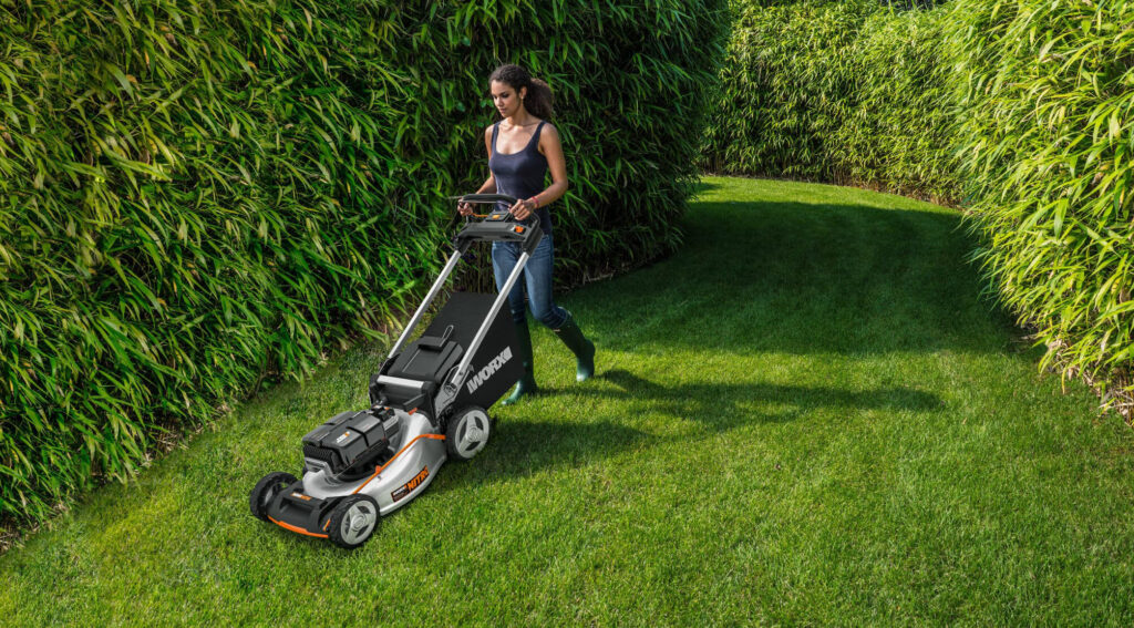 photo of a woman mowing her lawn with a maneuverable mower