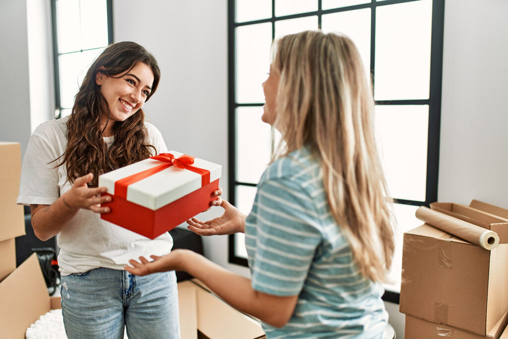 photo of a woman giving a new apartment gift to her friend