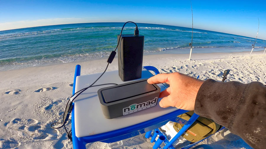 photo of a person accessing Nomad Internet at the ocean.